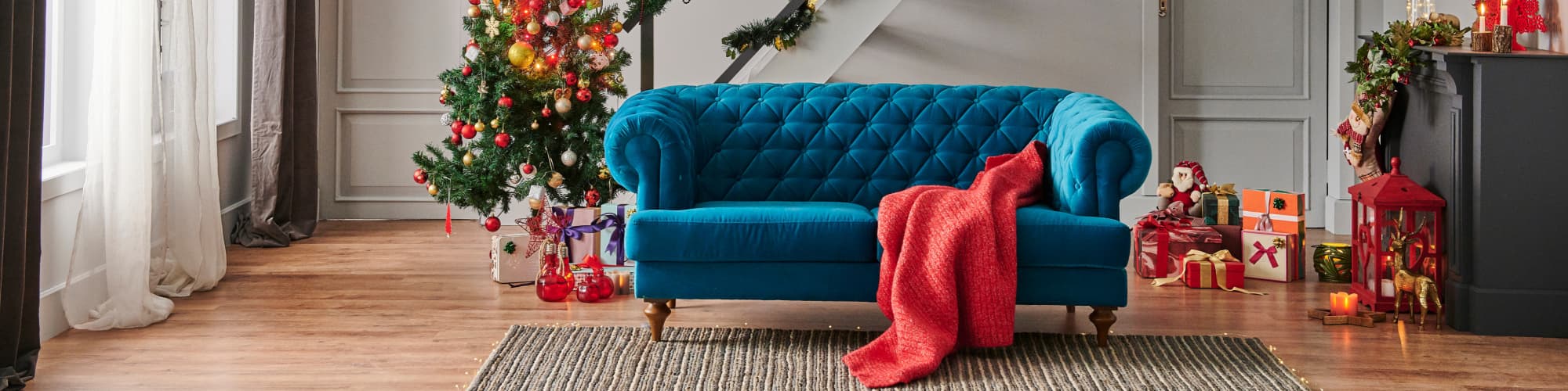 Blue sofa next to a christmas tree