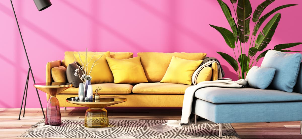 Bright modern living room with a yellow sofa, pink feature wall, indoor plants and contemporary furniture decor