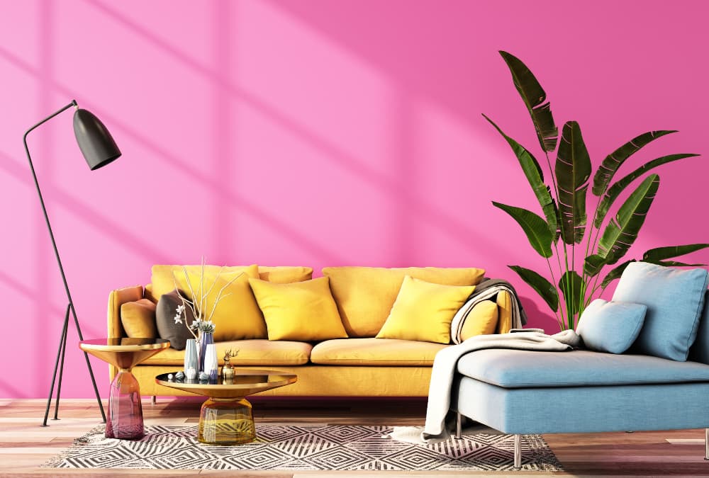Bright modern living room with a yellow sofa, pink feature wall, indoor plants and contemporary furniture decor